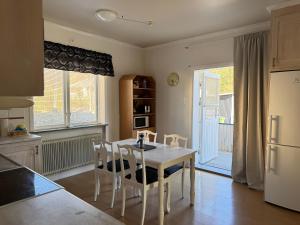 a kitchen with a white table and chairs and a refrigerator at Two room warm apartment Östavall in Östavall