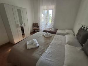 a bedroom with a large white bed with towels on it at Casa Framida in Cecina