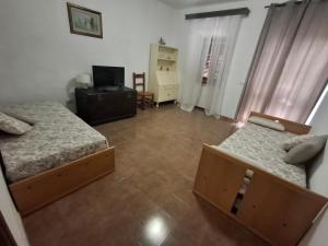 a small bedroom with two beds and a television at Casa Framida in Cecina
