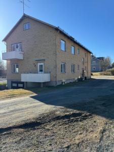 a large brick building on the side of a road at Two room warm apartment Östavall in Östavall