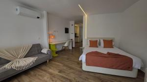 a bedroom with a bed and a couch at A Proa do Moliceiro - iConik Design Apartments in Aveiro +68 photos