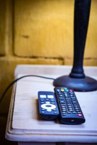 two remote controls sitting on a table next to a lamp at Mercy Tree Manor in eMalahleni