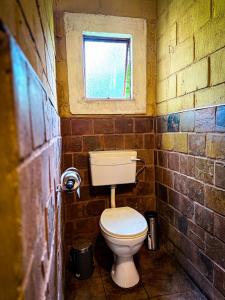 a small bathroom with a toilet in a brick wall at Mercy Tree Manor in eMalahleni +9 photos