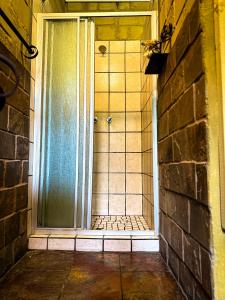 an open door to a bathroom with a brick wall at Mercy Tree Manor in eMalahleni