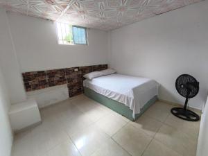 a small bedroom with a bed and a window at Casa Finca la Casona con Piscina Privada - Cerca al Parque Tayrona in Santa Marta