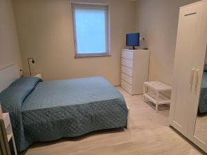 a bedroom with a bed and a television in it at Casa Paolina in Premeno