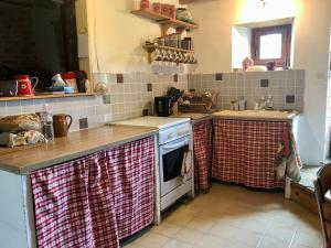 a kitchen with a sink and a stove top oven at Petit chalet rénové in Grandrif +12 photos
