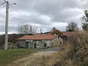 an old stone house with a red roof on a road at Petit chalet rénové in Grandrif