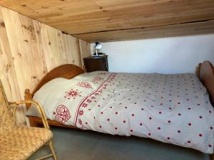 a bed in a room with a wooden ceiling at Petit chalet rénové in Grandrif