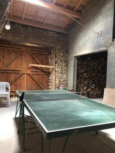 a ping pong table in a room with a wall at Petit chalet rénové in Grandrif