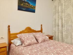 ロス・ジャノス・デ・アリダネにあるApartamentos los Llanos de Aridaneのベッドルーム1室(木製ヘッドボード付きのベッド1台付)
