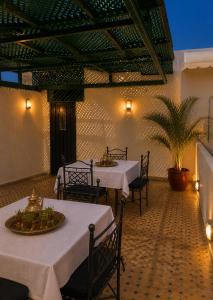 a restaurant with two tables and chairs and a palm tree at RIAD YOUSSEF in Fez +74 photos
