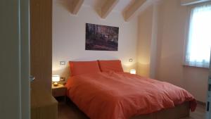 a bedroom with a red bed and a window at Villa Ducati in Vattaro