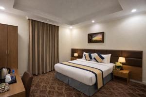 a hotel room with a bed and a desk at Al Fakhama Aldahbai Abi Zar - الفخامه الذهبي ابي ذر in Medina