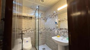 a bathroom with a shower and a toilet and a sink at Al Fakhama Aldahbai Abi Zar - الفخامه الذهبي ابي ذر in Medina