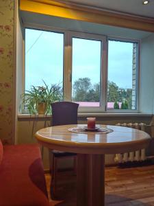 a table with a candle on it in a room with windows at Apartamenti dzīvoklis Ogre. in Ogre