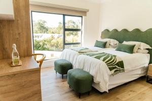 a bedroom with a large bed with a green headboard at Pause Guesthouse in Clarens
