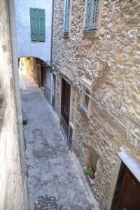アプリカーレにあるCuor di borgoの緑窓のある古い石造りの建物内の路地