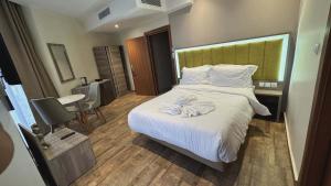 a hotel room with a bed with a flower on it at Hôtel Corner King in Skikda