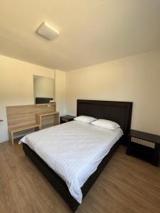 a bedroom with a bed and a desk and a mirror at NMS Promet in Mrkonjić Grad