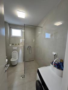 a white bathroom with a shower and a toilet at NMS Promet in Mrkonjić Grad +11 photos