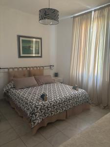 a bedroom with a bed with a black and white comforter at Casa Elisa 10 B in Bellaria-Igea Marina