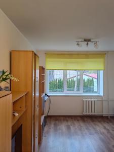 an empty room with a large window with yellow curtains at Apartamenti dzīvoklis Ogre. in Ogre