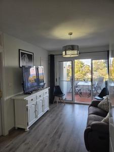 a living room with a flat screen tv and a couch at casa Caithlyn in Peniscola