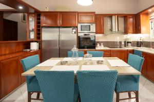 a kitchen with a table and blue chairs at Aeolus Villa Chios in Chios