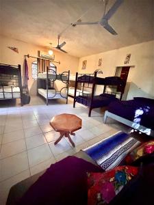 a living room with bunk beds and a table at Hostalito Lahar in Bacalar