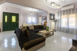 a living room with a couch and a green door at Aeolus Villa Chios in Chios