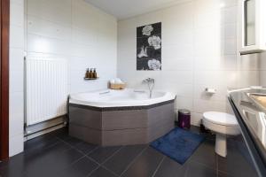 a white bathroom with a tub and a toilet at Aeolus Villa Chios in Chios +23 photos