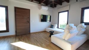 a living room with a white couch and windows at Ianos Living Spaces - 03 in Korinthos