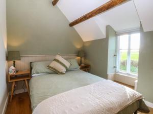 a bedroom with a bed and a window at Seren Fach in Pwllheli