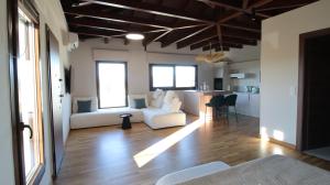 a living room with two white couches and a kitchen at Ianos Living Spaces - 03 in Korinthos