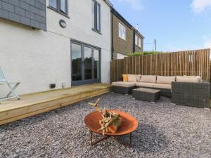a backyard with a couch and a coffee table at Seren Fach in Pwllheli