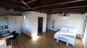 a bedroom with a white bed and a wooden floor at Ianos Living Spaces - 03 in Korinthos