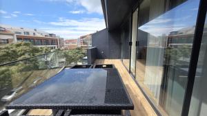 a glass table on the balcony of a building at A Proa do Moliceiro - iConik Design Apartments in Aveiro