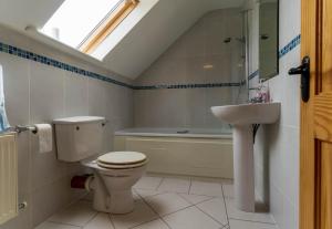 a bathroom with a toilet and a sink and a bath tub at Bray Head View 2 in Clynacartan +10 photos