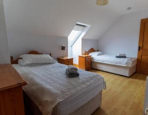 a bedroom with two beds and a window at Bray Head View 2 in Clynacartan