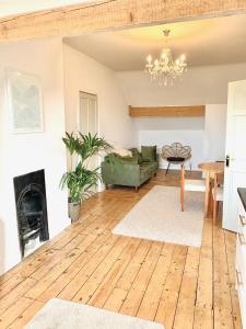 a living room with a fireplace and a green couch at Escape to Lytham St. Annes in Lytham St Annes