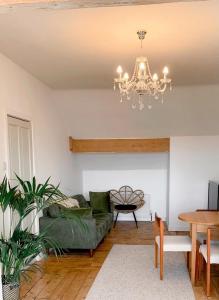 a living room with a green couch and a chandelier at Escape to Lytham St. Annes in Lytham St Annes
