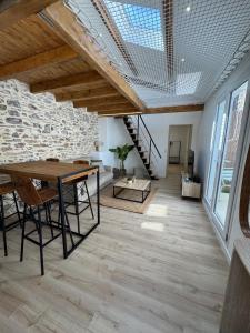 a living room with a table and a stone wall at T3climatisé Hyper centre 2 Chambres Terrasse in Sète