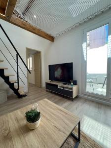 a living room with a television and a table at T3climatisé Hyper centre 2 Chambres Terrasse in Sète