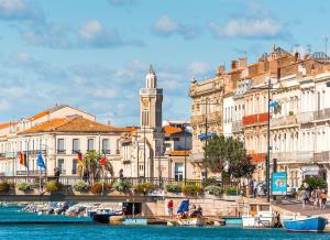 a group of buildings with a clock tower and water at T3climatisé Hyper centre 2 Chambres Terrasse in Sète