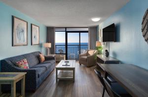 a living room with a couch and a table at Landmark Resort in Myrtle Beach