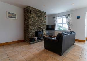 a living room with a couch and a fireplace at Bray Head View 2 in Clynacartan
