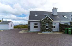 a house with a gravel driveway in front of it at Bray Head View 2 in Clynacartan