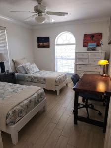 a bedroom with two beds and a desk and a dresser at Turtle Caye in Sanibel