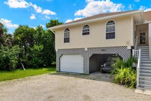 a house with a garage with a car in it at Turtle Caye in Sanibel